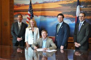 Ken Clark (left) at a bill signing to help Military families, with Governor Hickenlooper, May 2013